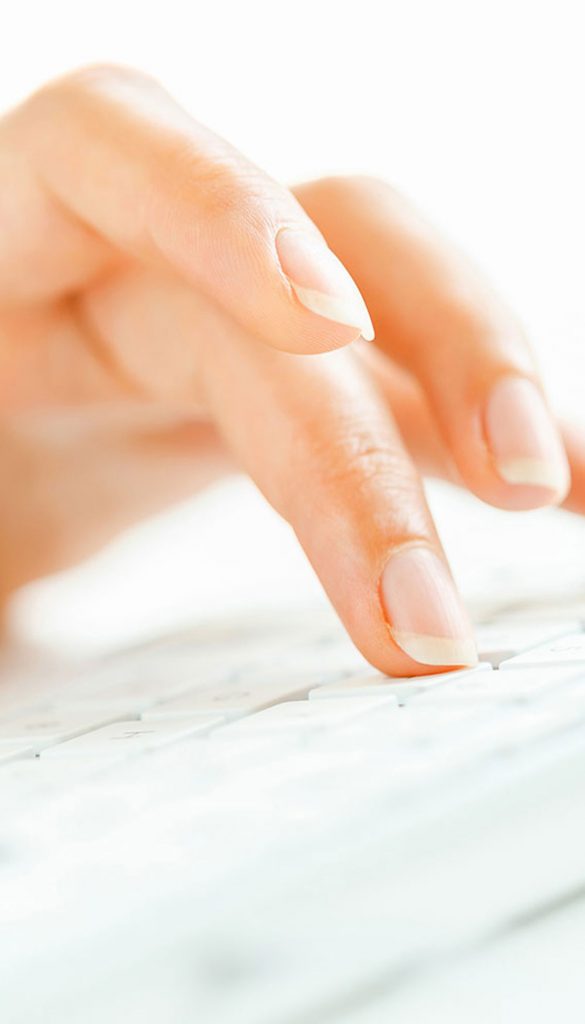 Close up of a hand typing on a keyboard.